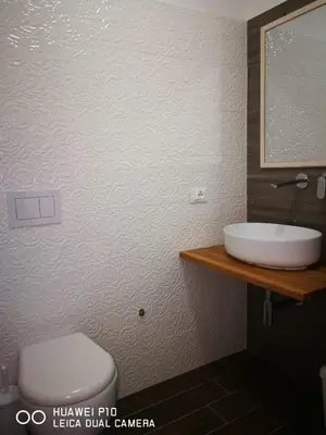 a bathroom with a sink and a toilet and a mirror at Capozafferano-Casa Carola in Santa Flavia