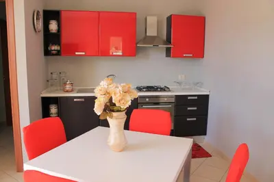 a kitchen with a table with a vase of flowers on it at Ville Tiffany in Campofelice di Roccella