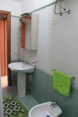 a bathroom with a sink and a toilet and a mirror at Ville Tiffany in Campofelice di Roccella