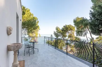a patio with a table and chairs on a balcony at Villa con accesso al mare e vista mozzafiato in Palermo