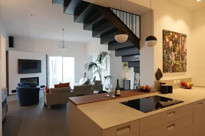 a kitchen and living room with a spiral staircase at Villa con accesso al mare e vista mozzafiato in Palermo