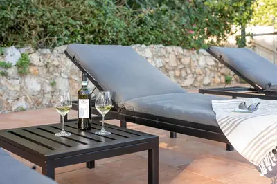 a bed with two glasses of wine on a table at Villa con accesso al mare e vista mozzafiato in Palermo