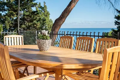 a wooden table with chairs and a vase on it at Villa con accesso al mare e vista mozzafiato in Palermo