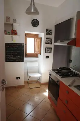 a kitchen with a stove and a chair and a window at La Casetta al Mercato del Capo in Palermo