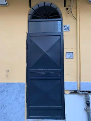 a black door on the side of a building at La Casetta al Mercato del Capo in Palermo