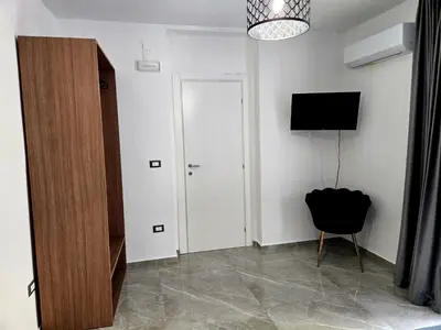 a room with a door and a television and a chair at Vicoletto Natalia - Proppro SRL- Palermo in Palermo