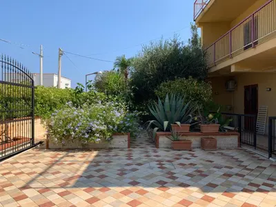 a patio with potted plants and a fence at Villino Toti e Silvana - a 50 mt dal mare in Carini