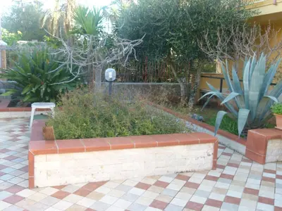 a brick bench in a garden with plants at Villino Toti e Silvana - a 50 mt dal mare in Carini