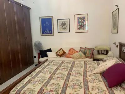 a bedroom with a large bed and a couch at Villino Toti e Silvana - a 50 mt dal mare in Carini
