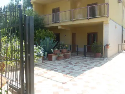 a courtyard with potted plants and a fence at Villino Toti e Silvana - a 50 mt dal mare in Carini