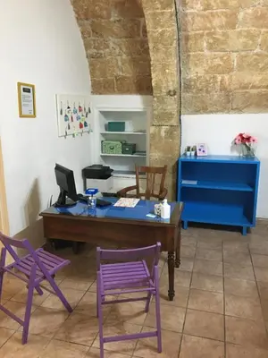 a desk and two purple chairs in a room at Terrasini 2000 Casa Vacanze in Terrasini