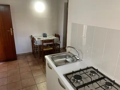 a kitchen with a stove and a sink and a table at Terrasini 2000 Casa Vacanze in Terrasini