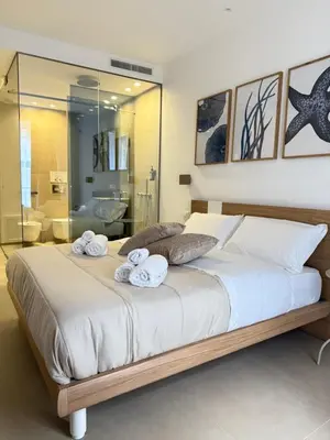 a bedroom with a large bed with towels on it at Santa Rosalia Suites in Palermo