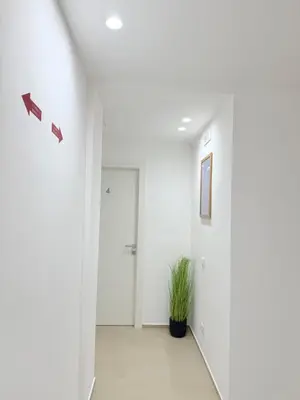 a hallway with white walls and a potted plant at Santa Rosalia Suites in Palermo
