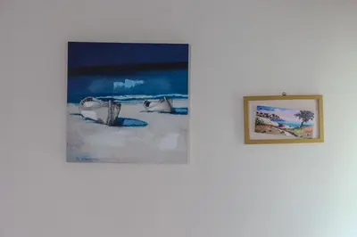 two paintings on a wall next to a picture of the beach at Casa Vacanze Verdemare in Mondello