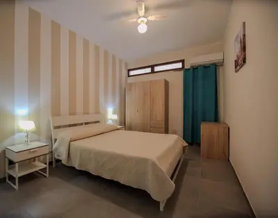 a bedroom with a bed and a table with a lamp at Casa Vacanze Verdemare in Mondello