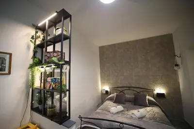 a bedroom with a bed and a shelf with plants at T&F Casa al Capo - In centro a Palermo in Palermo