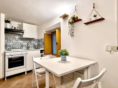 a kitchen with a white table and chairs at Nova Holidays in Palermo