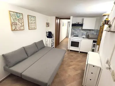 a living room with a couch and a kitchen at Nova Holidays in Palermo