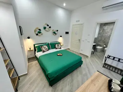 a bedroom with a green bed in a room at Kàlia Rooms in Palermo