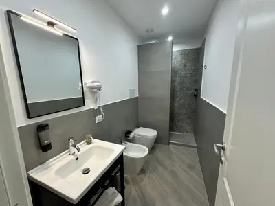 a bathroom with a sink and a toilet and a mirror at Kàlia Rooms in Palermo