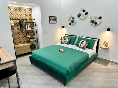 a bedroom with a green bed in a room at Kàlia Rooms in Palermo