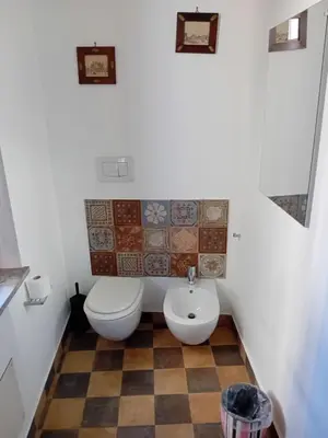 a bathroom with a toilet and a checkered floor at Vernagallo's House 2 in Palermo