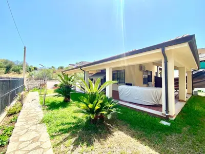 a small house with a bed in the yard at Villa Grace, beach 200 meters away, independent in Alcamo