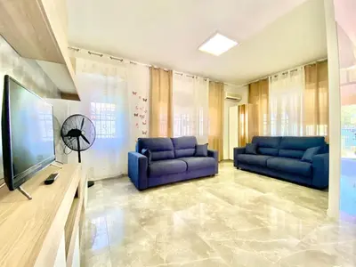 a living room with two blue couches and a television at Villa Grace, beach 200 meters away, independent in Alcamo