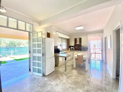 a kitchen with a white refrigerator and a table at Villa Grace, beach 200 meters away, independent in Alcamo