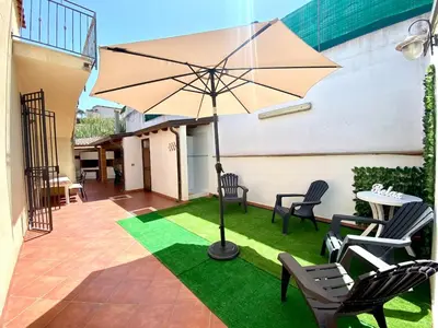 a patio with a table and chairs and an umbrella at Villa Grace, beach 200 meters away, independent in Alcamo