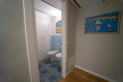 a bathroom with a toilet and a painting on the wall at Il Tesoretto 1 in Palermo