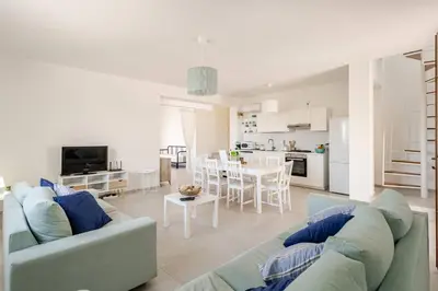 a living room with a couch and a table at Villa Four by Sicily Travelling Villas in Scopello