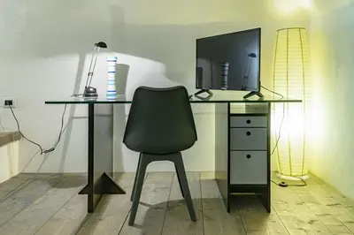 a desk with a chair and a desk with a television at La Terza Porta in Palermo