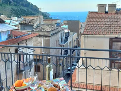 a vase with a crown on top of a table with cups at SoleMar in Castellammare del Golfo
