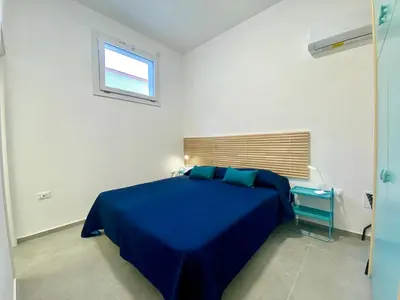 a blue bed in a white room with a window at Casa La Mamà, a 150 mt dal mare in Alcamo