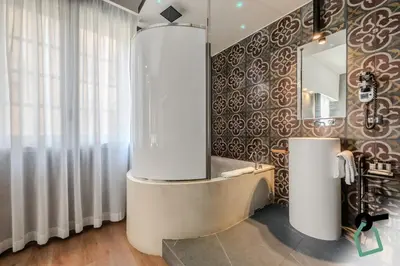 a bedroom with a large white bed with white curtains at HOTIDAY Palermo Palco Noir in Palermo