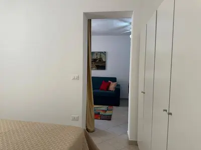 a bedroom with a bed and a blue couch at Soraya House Next quattrocanti in Palermo