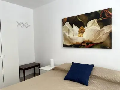 a bedroom with a painting of flowers on the wall at Soraya House Next quattrocanti in Palermo