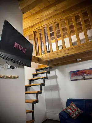 a stairway with a television and wooden ceiling at Il carrettiere in Termini Imerese