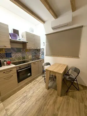 a kitchen with a wooden table and chairs in it at My Life in Palermo