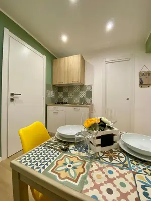 a kitchen with a table with plates and glasses on it at A Casa di Jimmy in Palermo