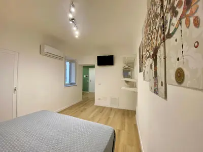a bedroom with a bed and a tv on a wall at A Casa di Jimmy in Palermo