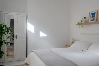 a white bedroom with a bed and a glass door at With love, Apartment 4 in Palermo