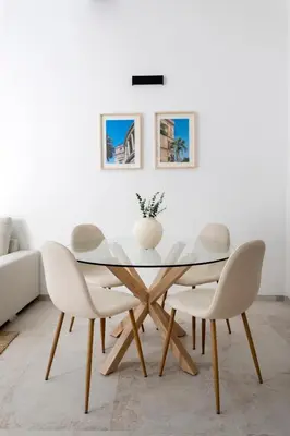 a dining room with a glass table and white chairs at With love, Apartment 4 in Palermo