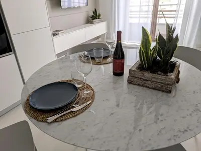 a dining table with glasses and a bottle of wine at Apartament and suite cavour 106 in Palermo