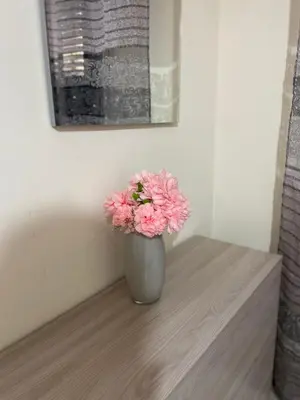 a vase with pink flowers sitting on a table at Alle spalle della cattedrale in Palermo
