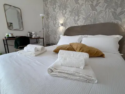 a bed with white blankets and pillows on it at Cinquantotto Cozy Rooms in Palermo