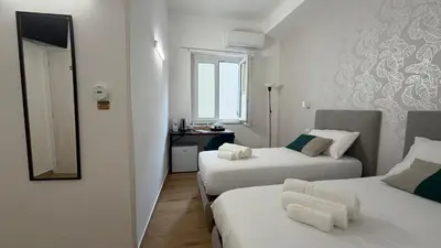 a hotel room with two beds and a mirror at Cinquantotto Cozy Rooms in Palermo