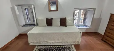 a bedroom with a bed with two windows at Palazzo Conte Federico Apartments in Palermo